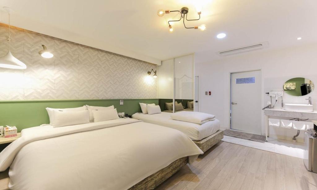 a bedroom with two beds and a fireplace at The Stay Series in Daegu