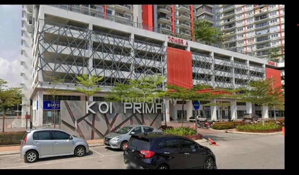 two cars parked in a parking lot in front of a building at KP1011 Guest House in Puchong