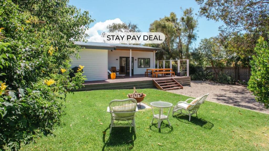 a yard with two chairs and a table in the grass at Seaside Serenity in Flinders