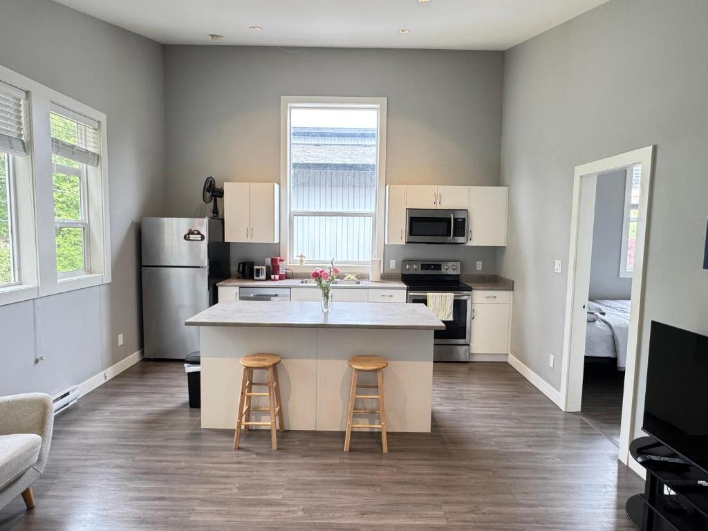 a kitchen with a counter and two bar stools at Lakeside Home on Second Floor in Langford
