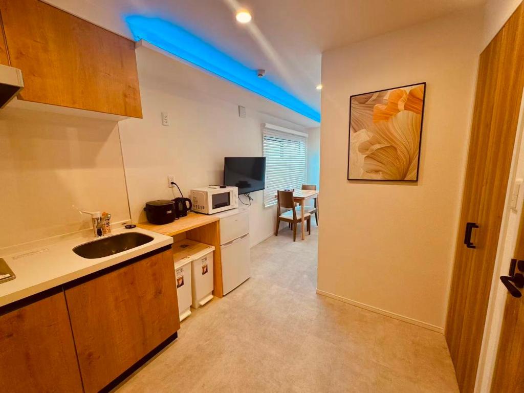 a small kitchen with a sink and a microwave at Simplex-Iriya in Tokyo