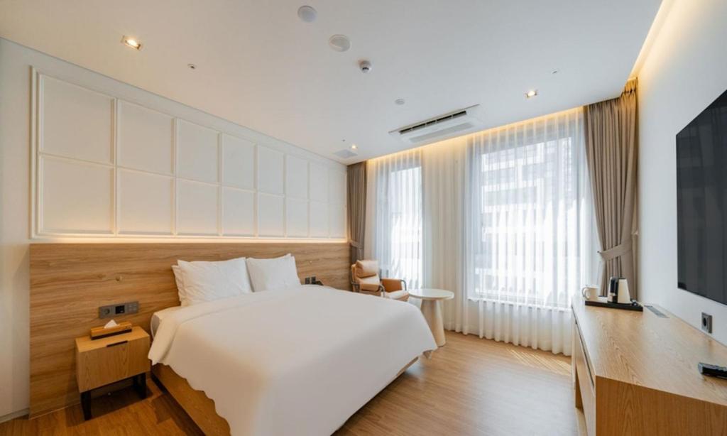 a hotel room with a large bed and a television at The hound hotel bandalseom2 in Ansan