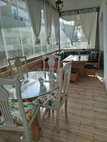a kitchen with a glass table and two chairs at mona in Sidi Rahal