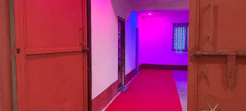 a red corridor with pink and blue lights at Hotel Sunrise inn in Nārdiganj