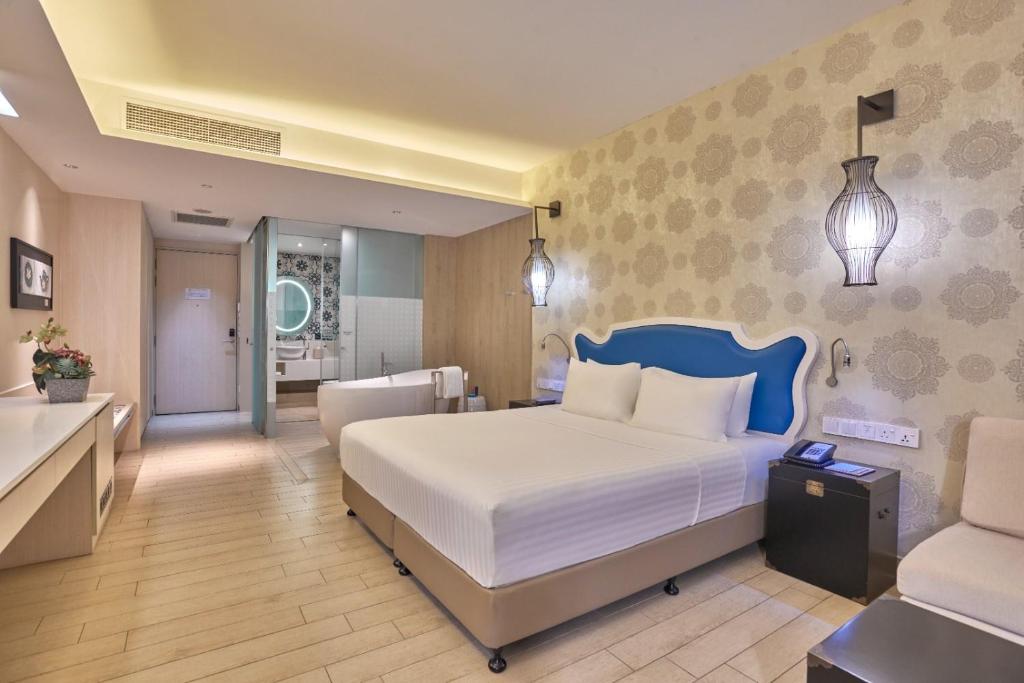 a bedroom with a large bed and a bathroom at Village Hotel Katong by Far East Hospitality in Singapore