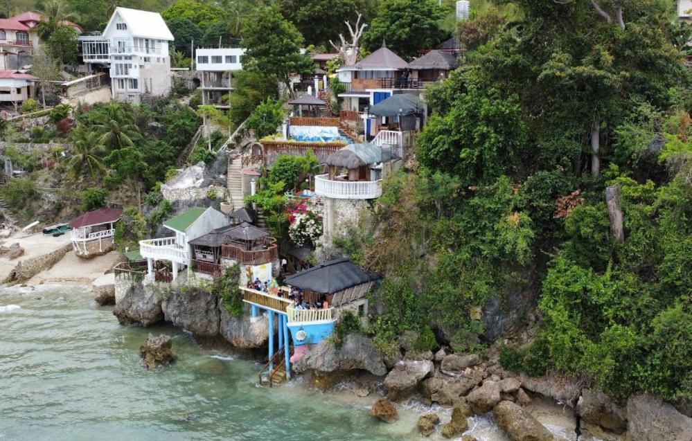 a group of houses on a hill next to the water at Cliff Cabanas by Hiverooms in Catmon