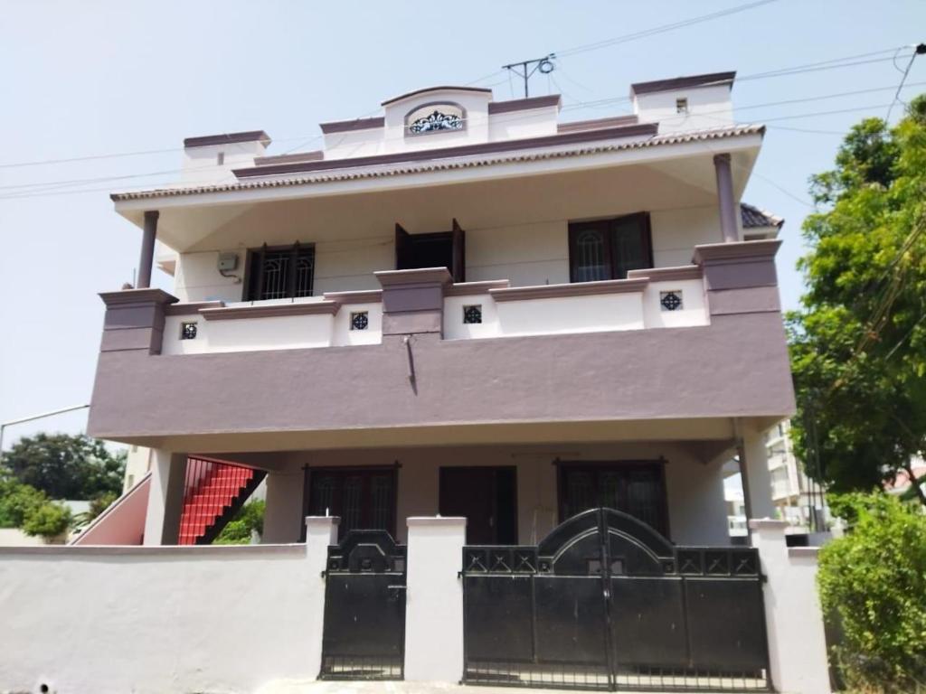 a large white house with a black gate at Sunstar in Coimbatore