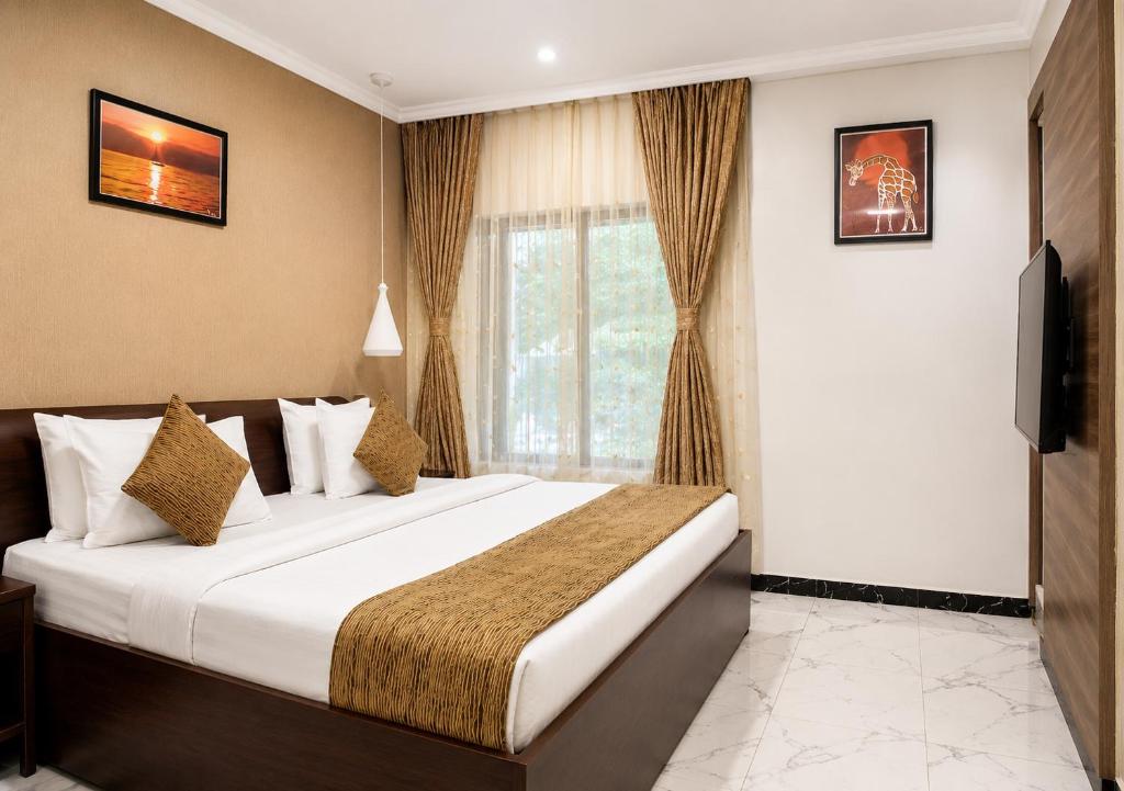 a hotel room with a bed and a television at Chelsea Hotel Abuja in Abuja