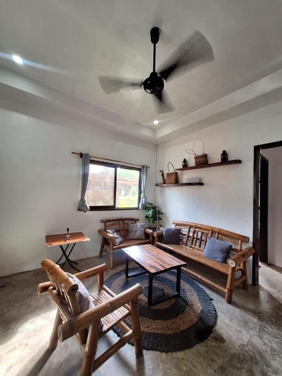 a living room with wooden furniture and a ceiling fan at Lio House 2 bedroom in El Nido Airport