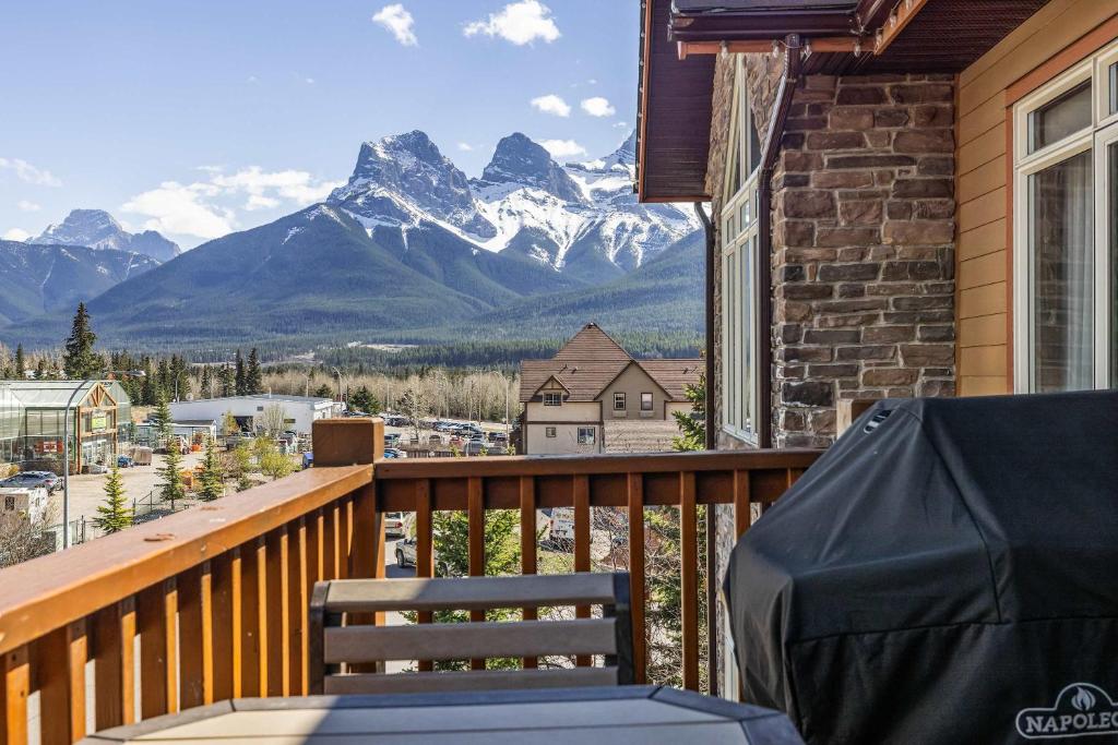 a chair on a balcony with a view of mountains at The Eagle Suite at Stoneridge Mountain Resort in Canmore
