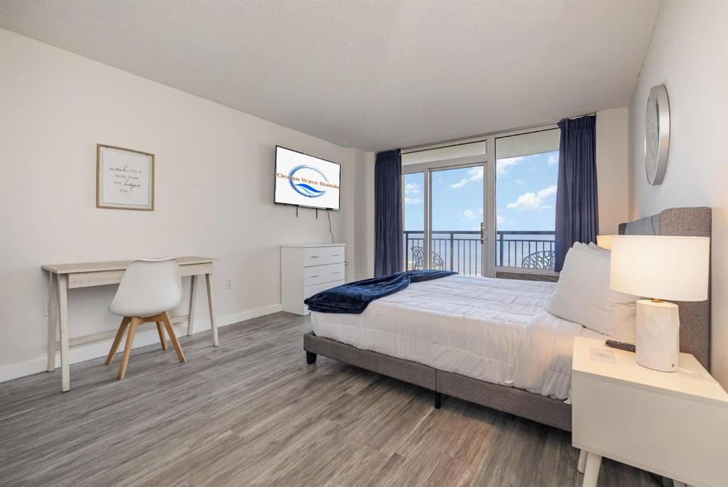 a bedroom with a bed and a desk with a window at Spacious Beach Condo Double Suite for Couples Getaway in Myrtle Beach