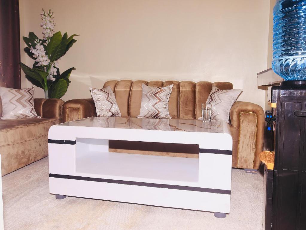 a white coffee table in a living room with a couch at Cozy homes kisii in Kisii