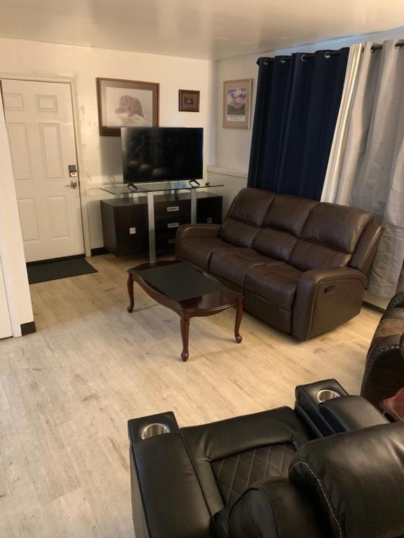 un salon avec un canapé en cuir et une table dans l'établissement 410 E 45th Unit 1, à Anchorage