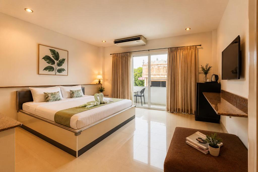 a bedroom with a large bed and a large window at Ree- Riverside hotel in Bangkok