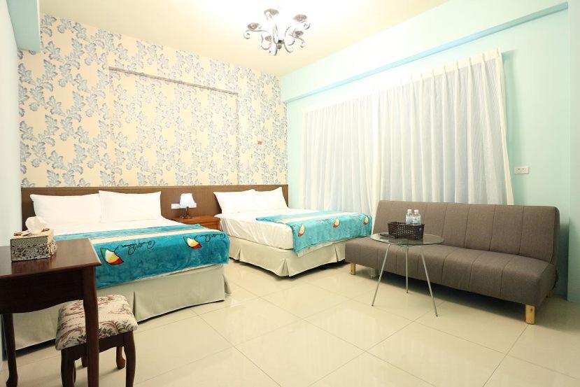 - un salon avec deux lits et un canapé dans l'établissement Marathon B&B, à Taïtung