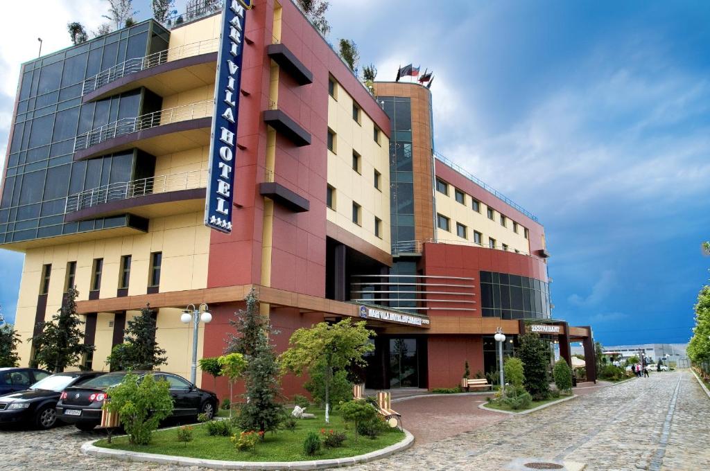 a building with a sign in front of it at Mari Vila Hotel in Bucharest