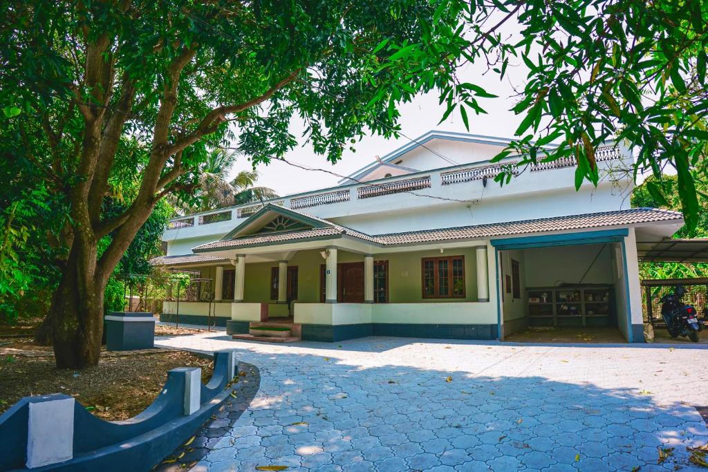 an old house with a tree in front of it at Athira Homestay in Kollengode
