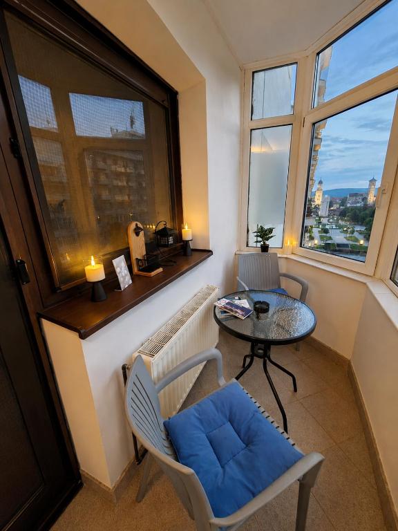 a small room with a table and chairs and a window at COZY PANORAMA Flat in Alba Iulia
