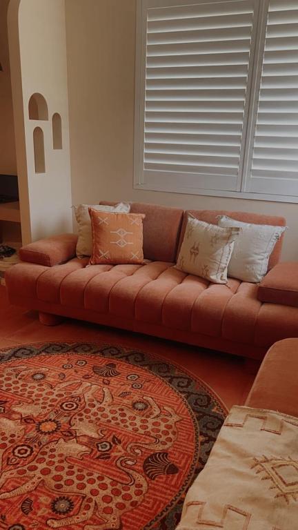 a brown couch in a living room with a rug at Le Maroc at Bar Beach in Newcastle