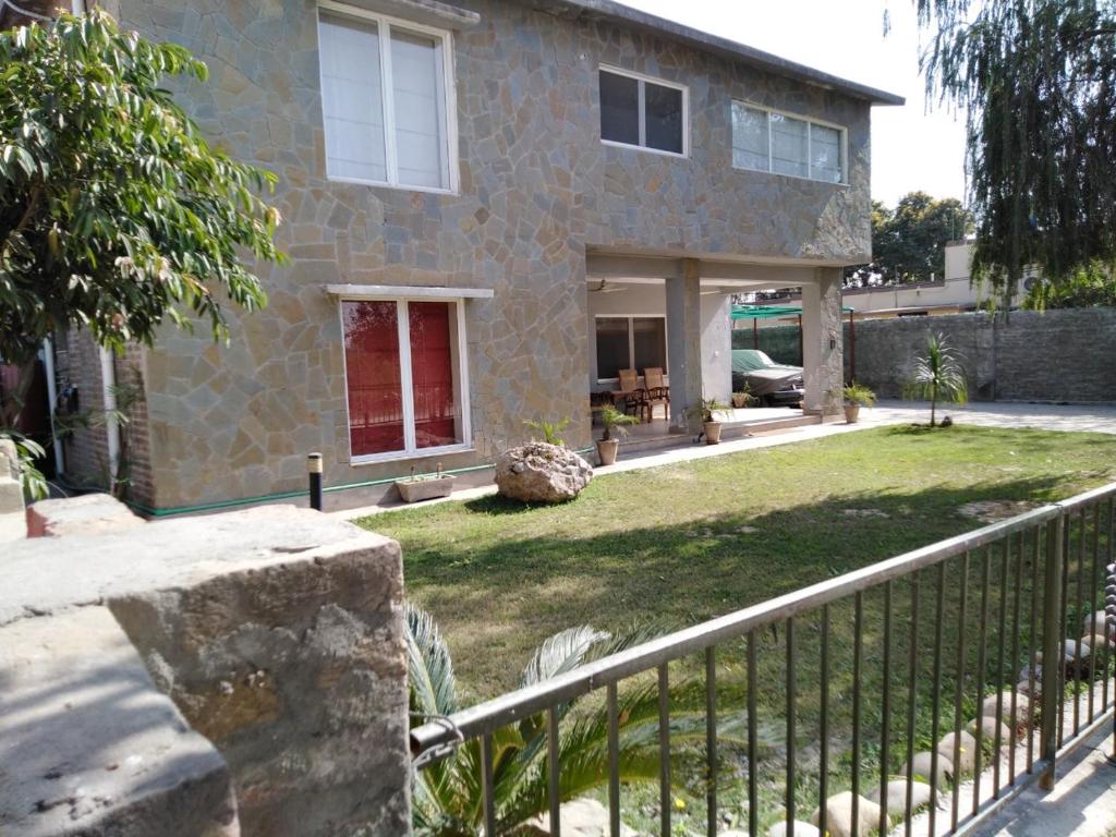 a stone house with a fence in front of it at Morgah Resort - Guest Rooms in Rawalpindi