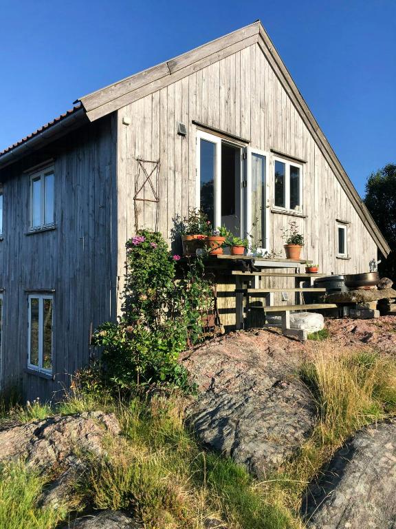a wooden house with a table in front of it at Architect-Designed House With Pier In Ny Hellesund in Søgne