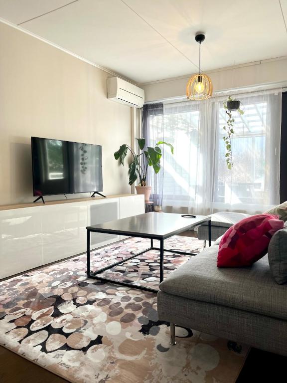 a living room with a coffee table and a couch at Saunallinen kolmio kahdella autopaikalla in Jyväskylä