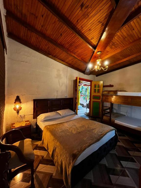 a bedroom with a large bed and a wooden ceiling at Casa de La Abuela Irene in Calarcá