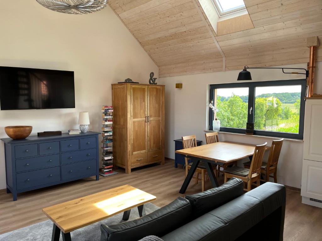 a living room with a table and a couch at großzügige Ferienwohnung mit weitem Ausblick in Lichtenberg