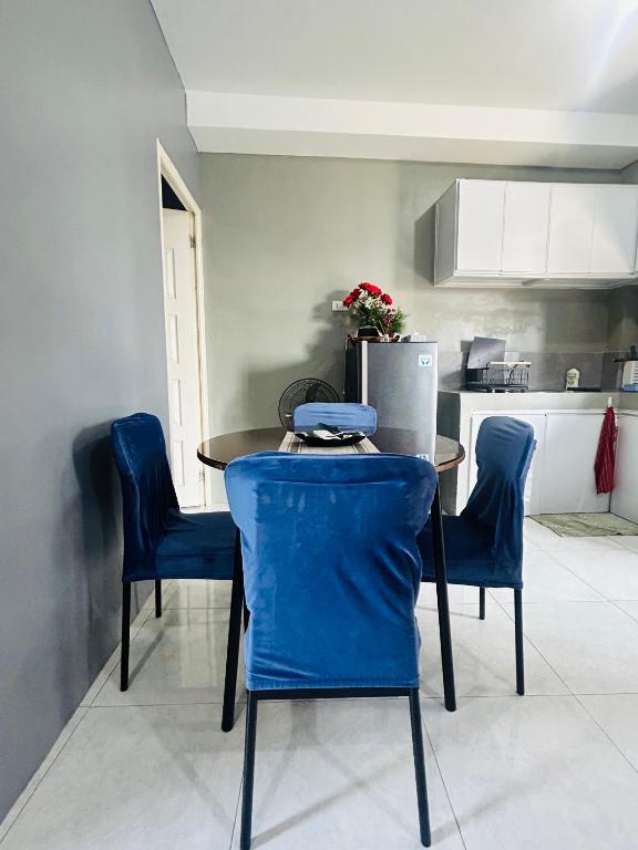 a kitchen with a table and chairs and a refrigerator at Dories Residences - Unit 5 in Pozorrubio