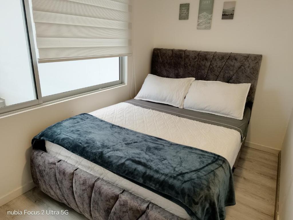 a bedroom with a large bed with a window at Room cerca al aeropuerto #3 in Bogotá