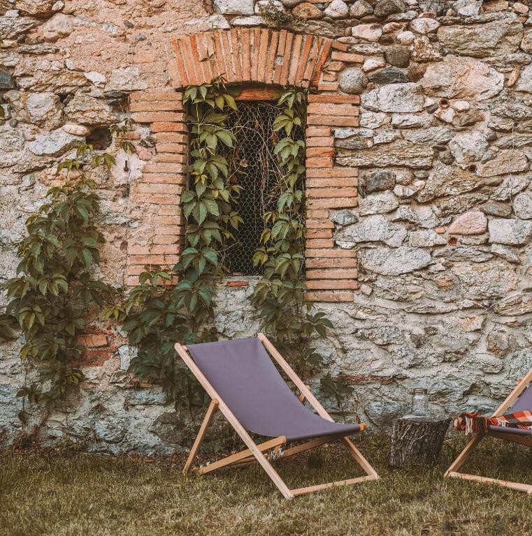a chair sitting in front of a stone wall at Cim's Apartments Cerdanya 2 in Bellver de Cerdanya