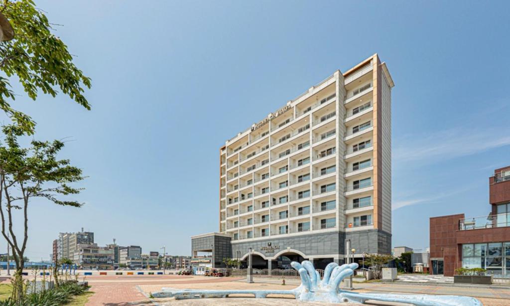 a large building with a statue in front of it at Mud Beach Hotel in Boryeong