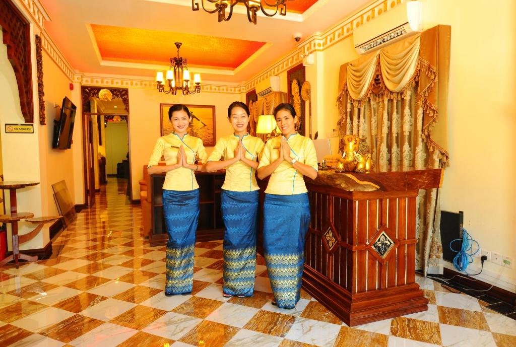 Três mulheres numa sala a amarrar os laços. em Union Square Hotel em Yangon
