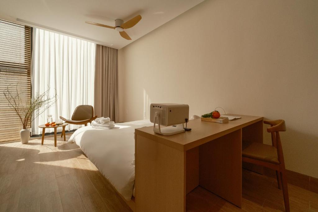 a bedroom with a bed and a desk with a computer on it at Elora House in Thôn Lại Thê