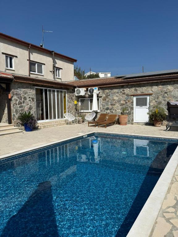 a large swimming pool in front of a house at Kassandra's Cottage in Vasa