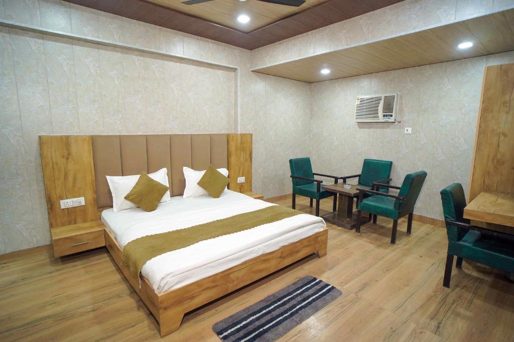 a bedroom with a bed and a table and chairs at Hotel Konark INN in Bareilly