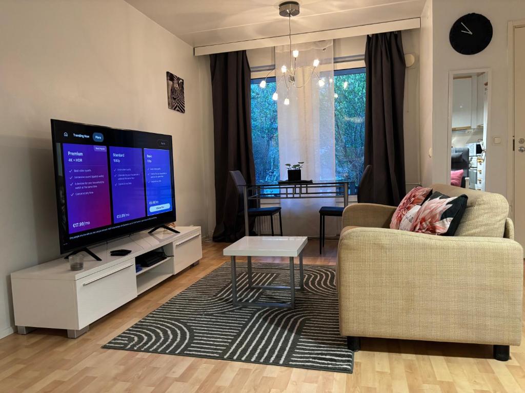 a living room with a tv and a couch and a table at Cozy Apartment with Private Sauna in Vaasa