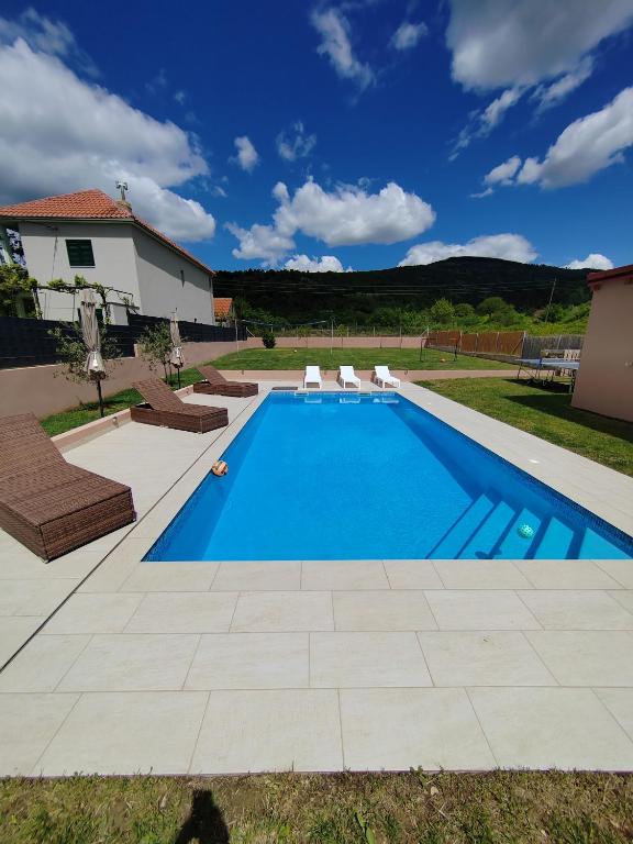 ein Swimmingpool in einem Garten mit einem Haus in der Unterkunft Villa Hirundinidae in Gornji Muć