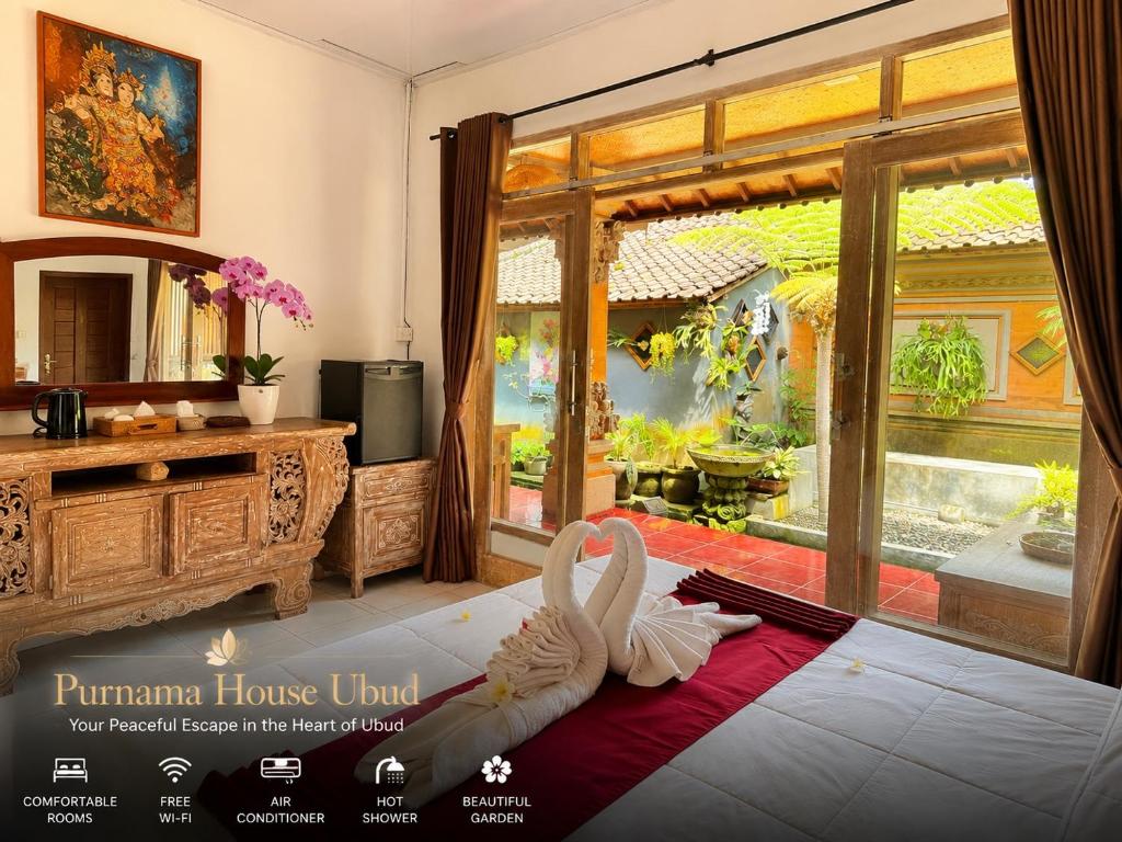 a bathroom with two swans sitting on the floor in front of a window at Purnama House Ubud in Ubud