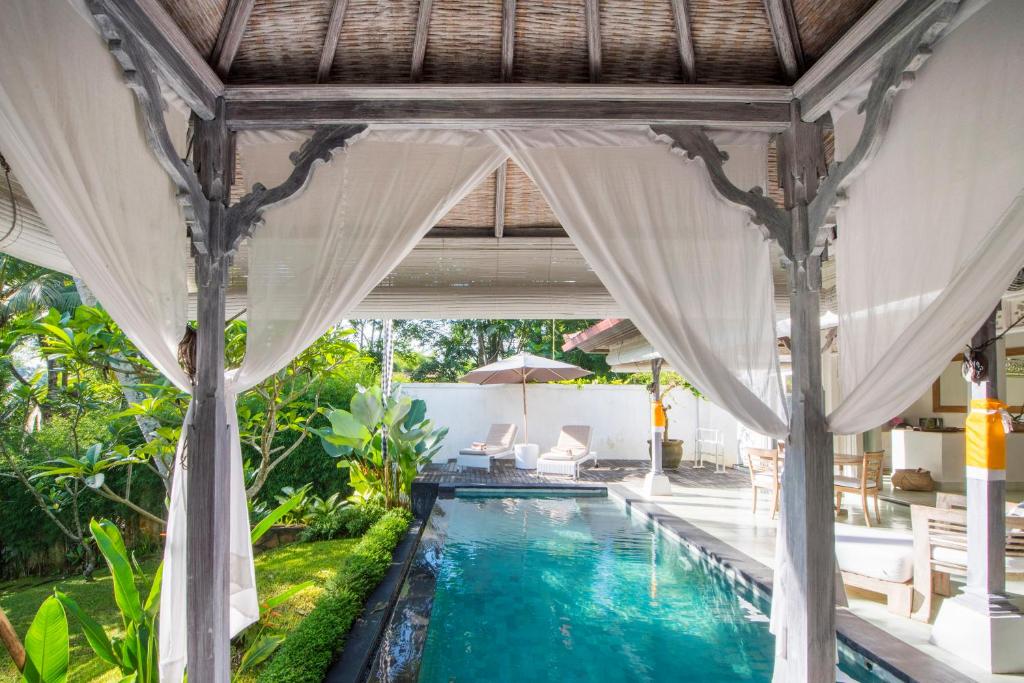 a pool in a villa with a canopy over it at Shamballa Moon in Ubud