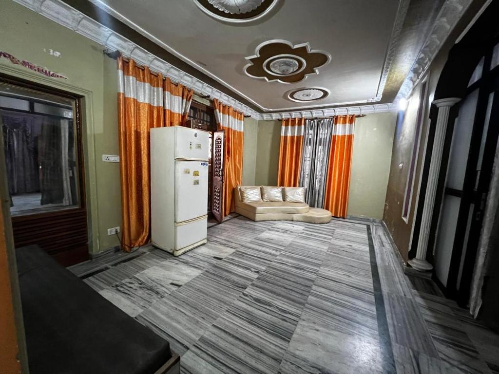 a living room with a refrigerator and a couch at Home stays subash nagar in Jammu