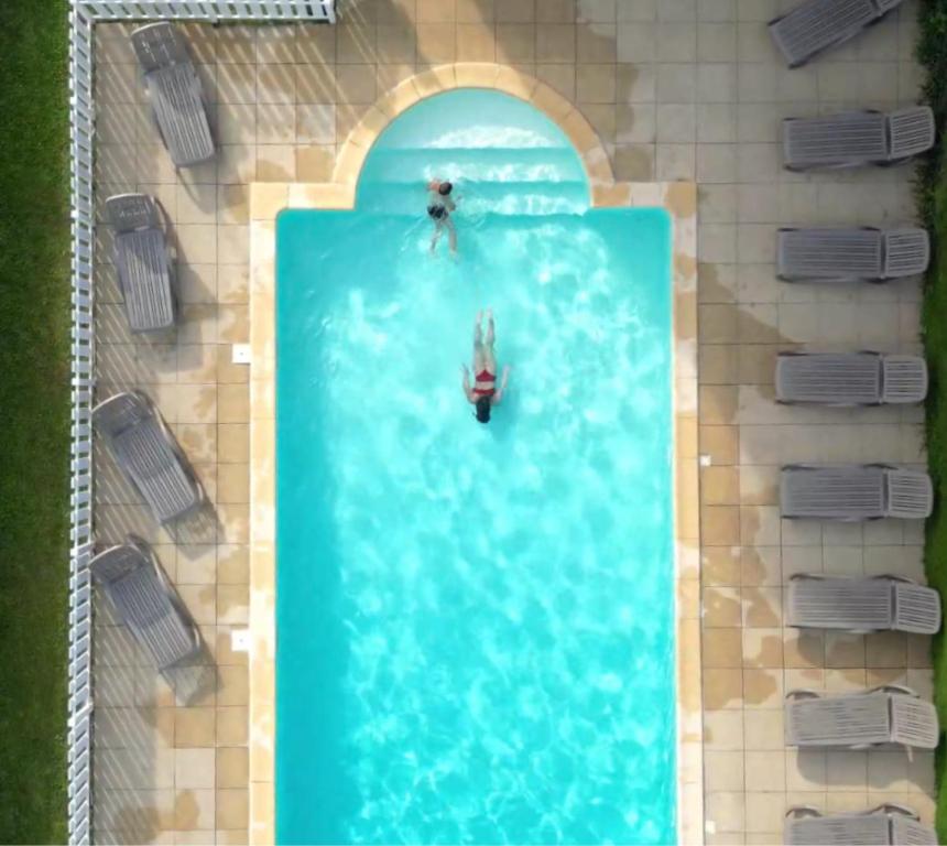 zwei Personen im Wasser in einem Schwimmbecken in der Unterkunft Hôtel Aurélia in Saint-Lary-Soulan