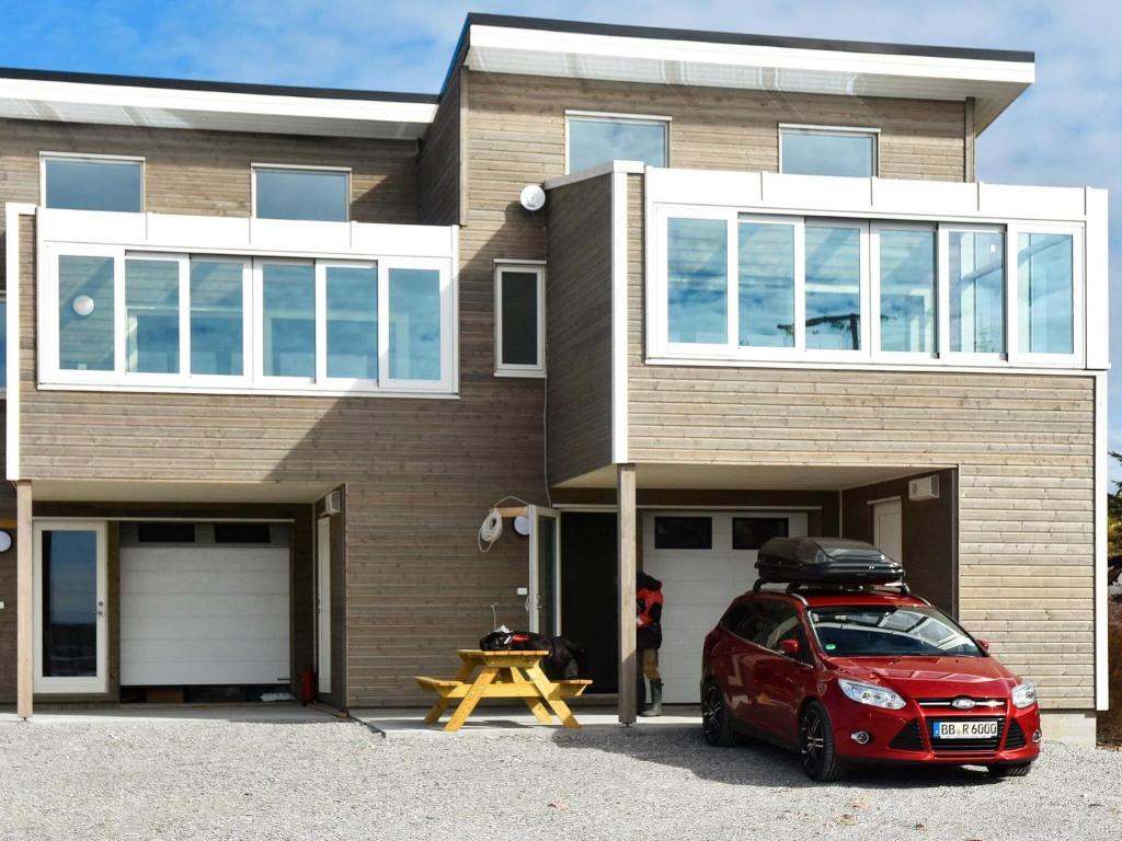a red car parked in front of a house at 6 person holiday home in Dyrvik in Dyrvik