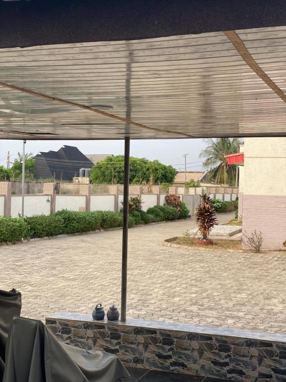 a table with an umbrella in a courtyard at PLV Apartment in Ilorin