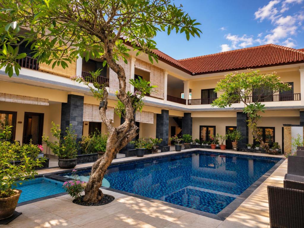a swimming pool in front of a villa at Radha Bali Hotel in Kuta