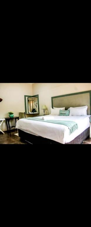 a bedroom with a large bed with white sheets and pillows at Zungu b&b in KwaDukuza