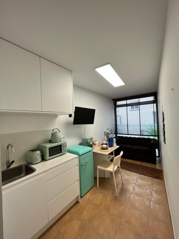 a kitchen with a blue refrigerator and a table at Estudio bajo la escalera in Redondela