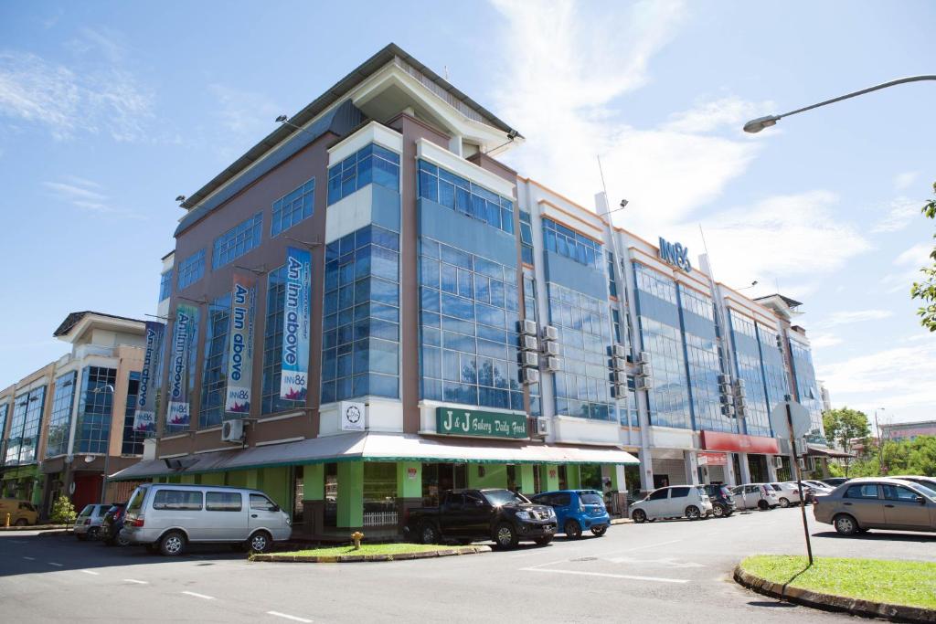 a large building with cars parked in a parking lot at Inn86 in Bintulu