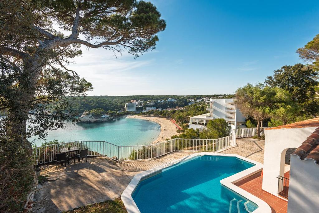 a house with a swimming pool and a view of a beach at Villa Casa de Olives by Escape Home in Cala Galdana