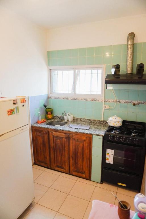 a kitchen with a stove and a refrigerator at La Casa de Doña Adela in Eugenio Bustos